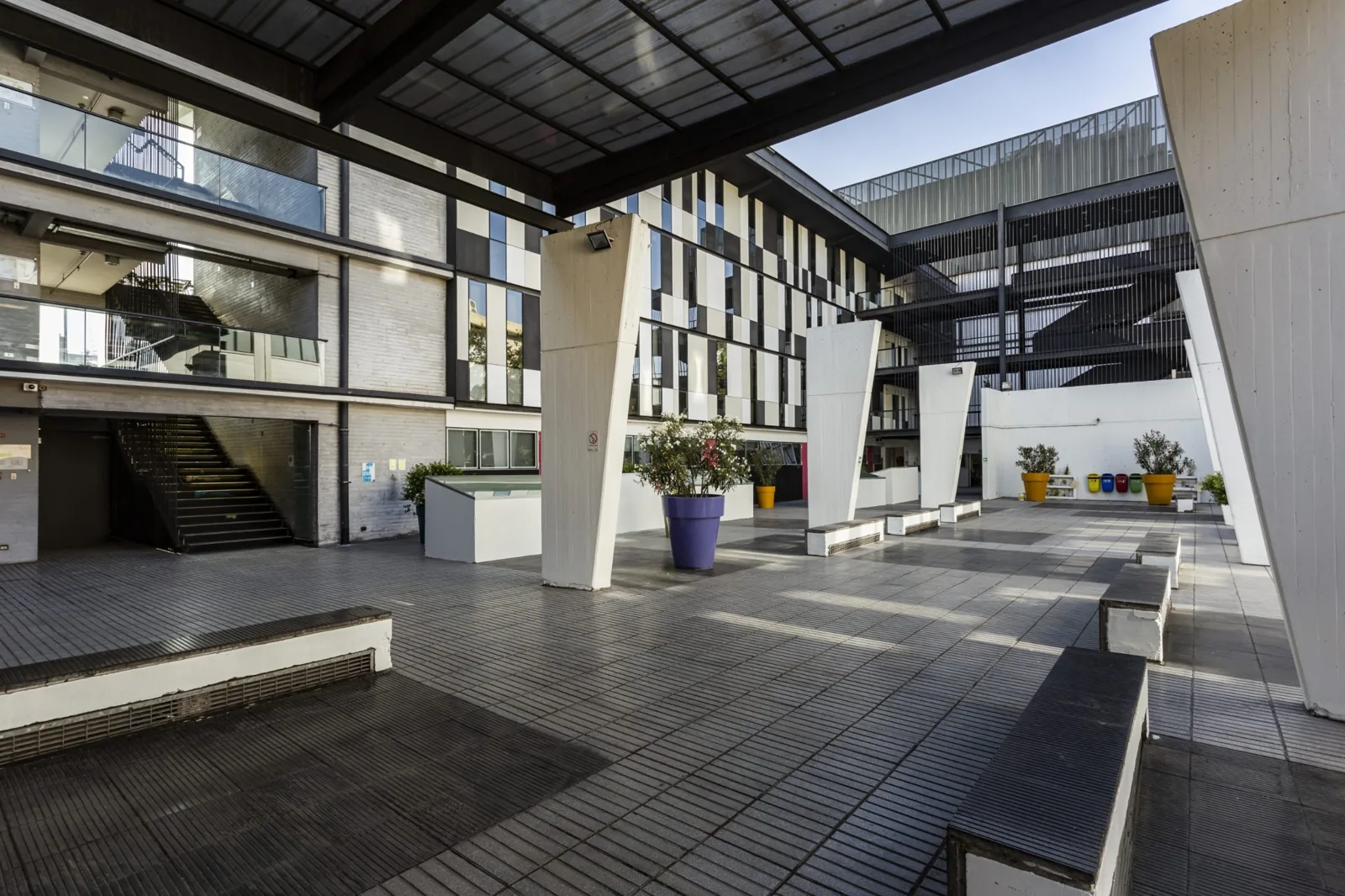 Patio interior de la facultad con pasillos y áreas de descanso